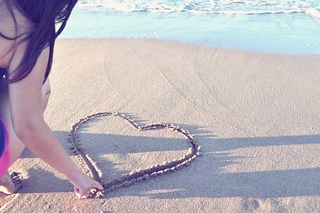 Un cœur dessiné dans le sable au bord de la mer